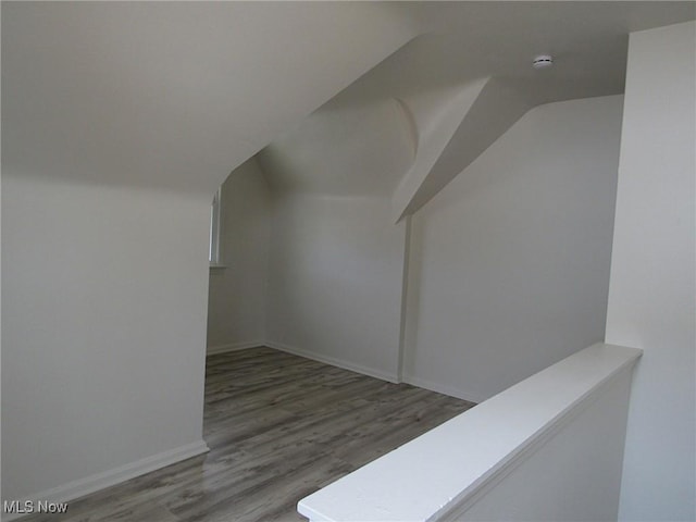 bonus room featuring lofted ceiling, baseboards, and wood finished floors