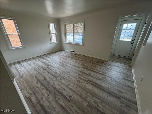 interior space with visible vents, baseboards, and wood finished floors