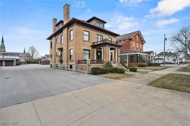 view of side of home featuring a chimney and brick siding