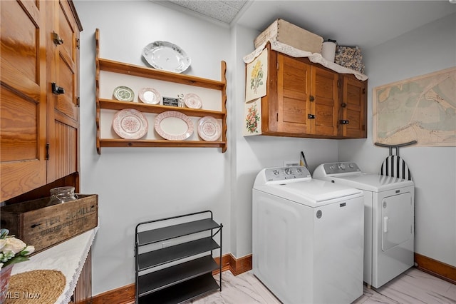 laundry area featuring marble finish floor, cabinet space, baseboards, and separate washer and dryer