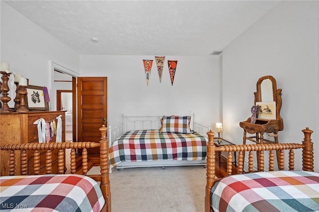 bedroom with carpet flooring, visible vents, and a textured ceiling