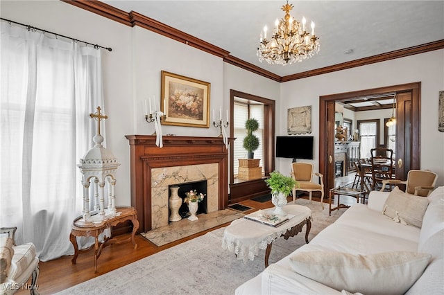 living room with a premium fireplace, ornamental molding, a wealth of natural light, and wood finished floors