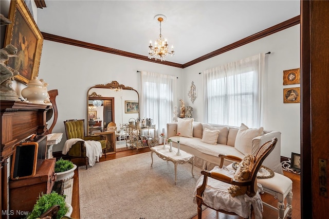 living room with an inviting chandelier, crown molding, and wood finished floors