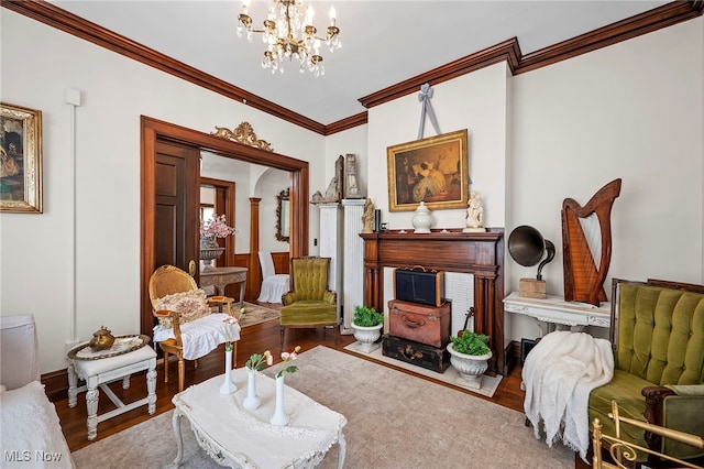 living area with a chandelier, crown molding, and wood finished floors