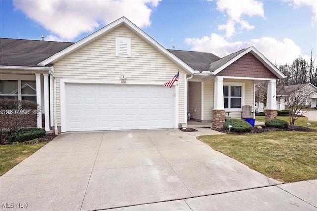 view of front of house featuring a front yard, concrete driveway, and an attached garage