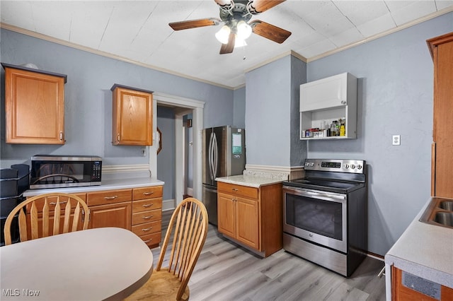 kitchen with ceiling fan, stainless steel appliances, light wood-style floors, light countertops, and crown molding