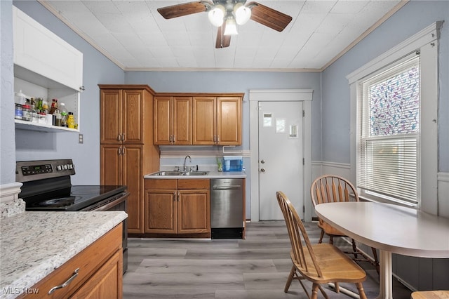 kitchen with stainless steel appliances, a sink, light countertops, and brown cabinets