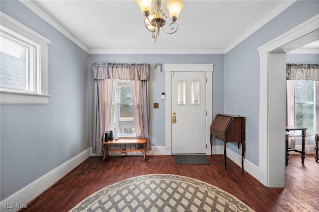 entrance foyer featuring an inviting chandelier, baseboards, ornamental molding, and wood finished floors