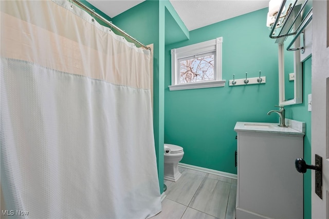 bathroom featuring vanity, toilet, and baseboards