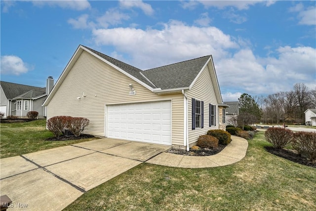 view of side of home featuring a yard, driveway, a shingled roof, and a garage