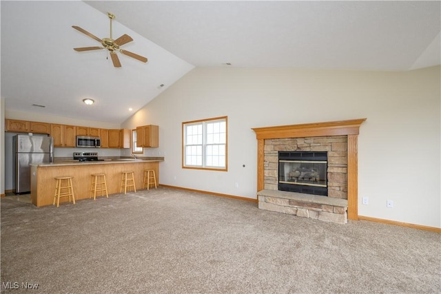 unfurnished living room featuring carpet, baseboards, and a stone fireplace