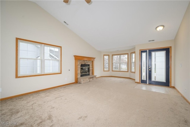 unfurnished living room featuring baseboards, visible vents, light colored carpet, a fireplace, and high vaulted ceiling