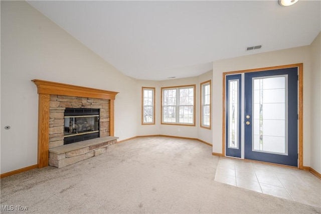 carpeted foyer entrance with visible vents, baseboards, lofted ceiling, tile patterned flooring, and a fireplace