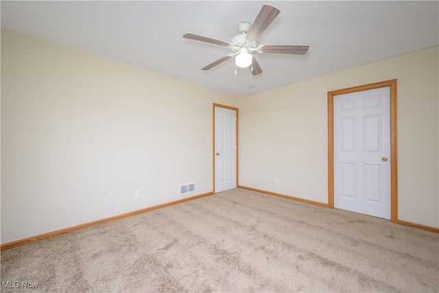 unfurnished room featuring a ceiling fan, carpet, visible vents, and baseboards