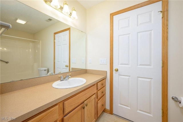 full bath featuring toilet, vanity, walk in shower, and visible vents