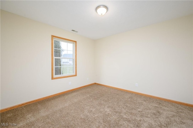 carpeted empty room featuring visible vents and baseboards