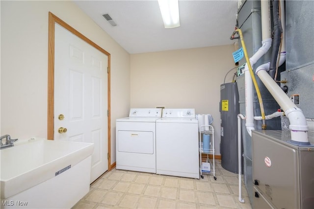 clothes washing area with laundry area, visible vents, electric water heater, light floors, and separate washer and dryer