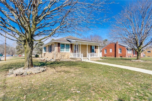 view of front facade with a porch, brick siding, and a front lawn