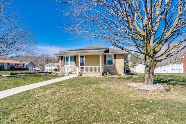 bungalow-style house with covered porch, fence, a front lawn, and brick siding