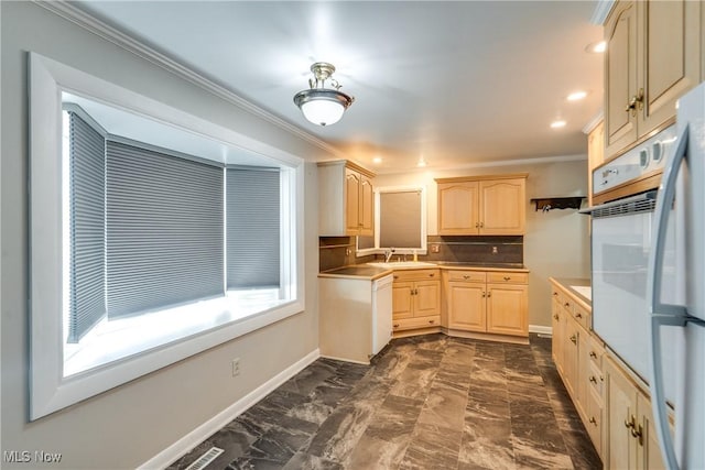 kitchen with crown molding, tasteful backsplash, light brown cabinets, a sink, and white appliances