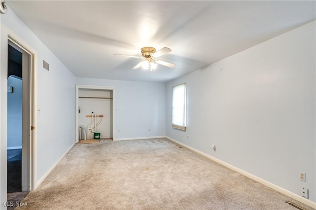 unfurnished room with baseboards, a ceiling fan, visible vents, and light colored carpet