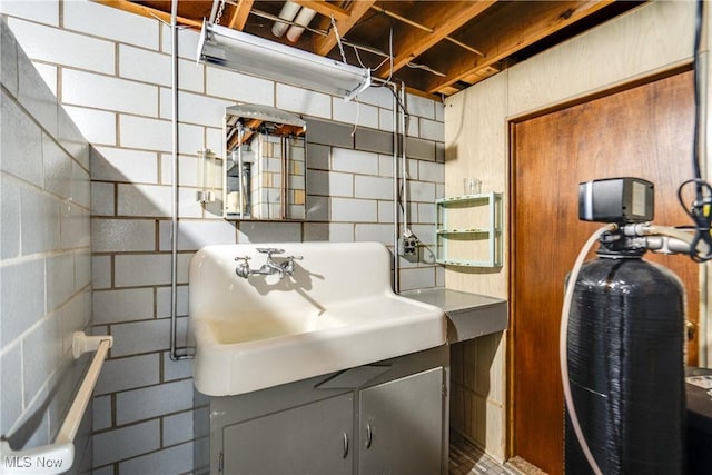 interior space featuring concrete block wall and a sink