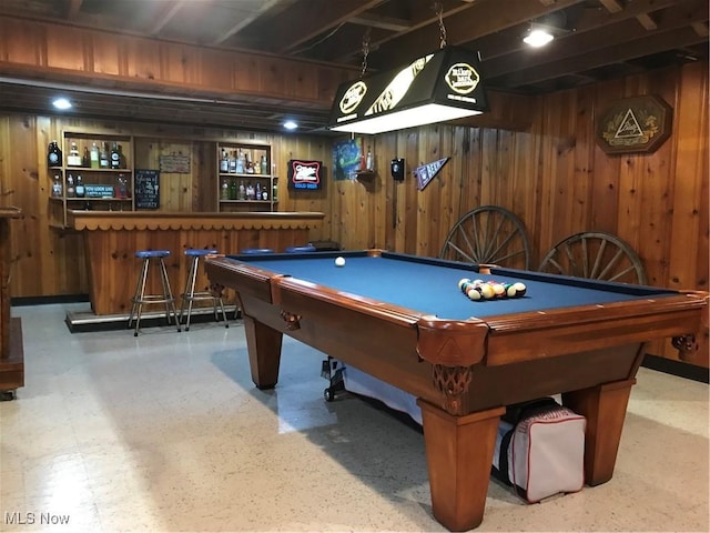 game room featuring pool table, wooden walls, and a bar