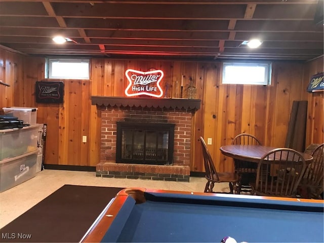 game room with wooden walls and a fireplace