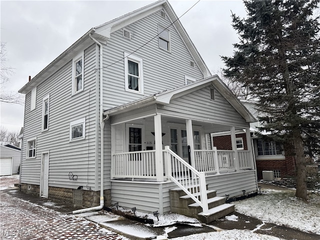 view of front facade featuring a porch and central AC