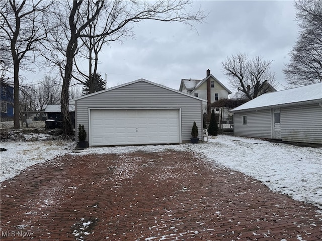 snow covered garage featuring a garage