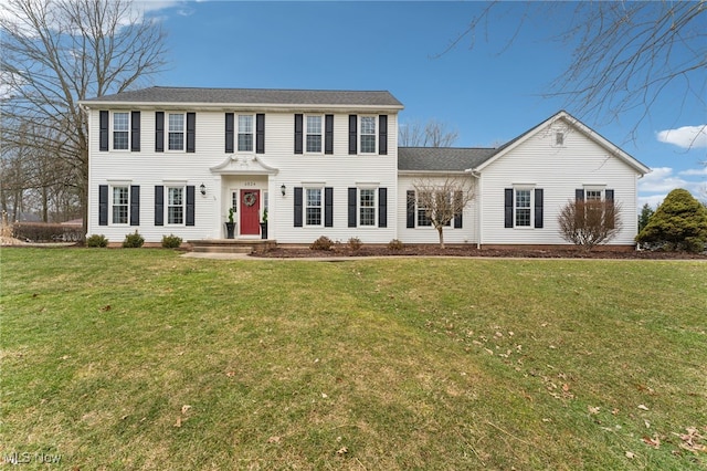 colonial-style house featuring a front yard