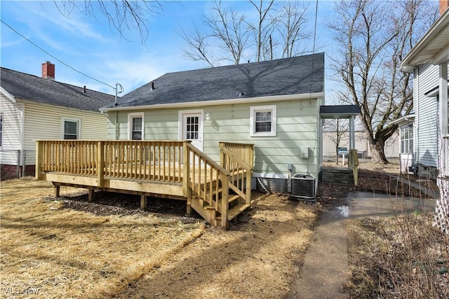 back of property with a deck, central AC unit, and a shingled roof