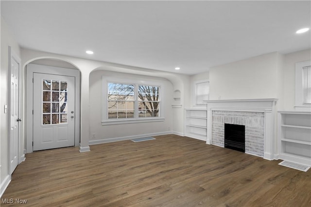 unfurnished living room featuring a fireplace, wood finished floors, visible vents, and recessed lighting