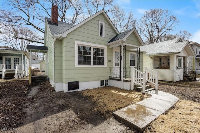 bungalow with a chimney, french doors, and roof with shingles