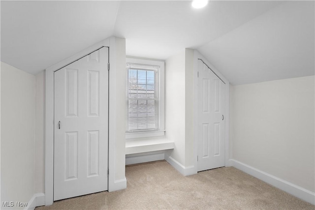 additional living space featuring carpet floors, baseboards, and lofted ceiling