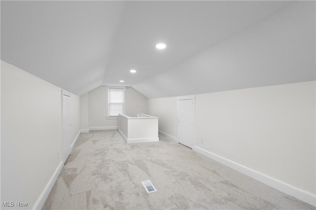 additional living space featuring lofted ceiling, recessed lighting, visible vents, light carpet, and baseboards