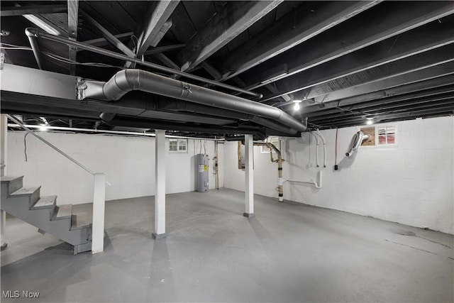 basement featuring stairs and electric water heater