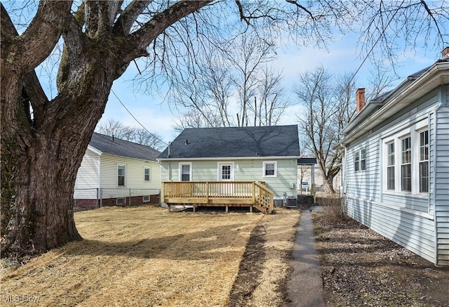 back of property with a lawn, central AC, and a wooden deck