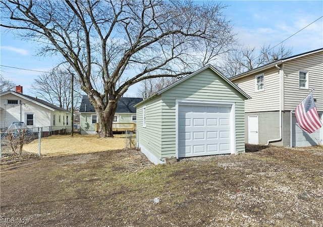 detached garage with driveway and fence