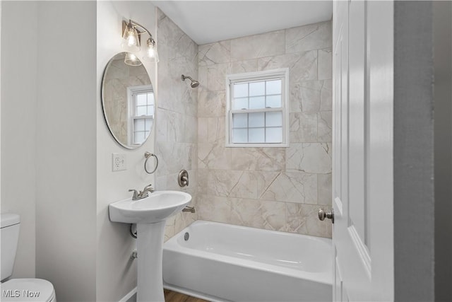 full bathroom with toilet, a healthy amount of sunlight, and tub / shower combination