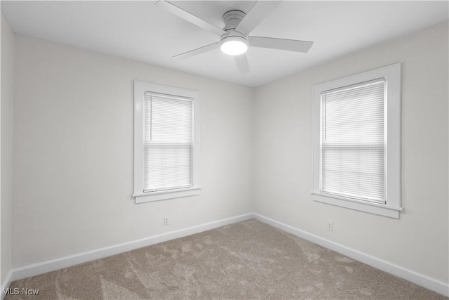 unfurnished room featuring carpet floors, a healthy amount of sunlight, baseboards, and a ceiling fan