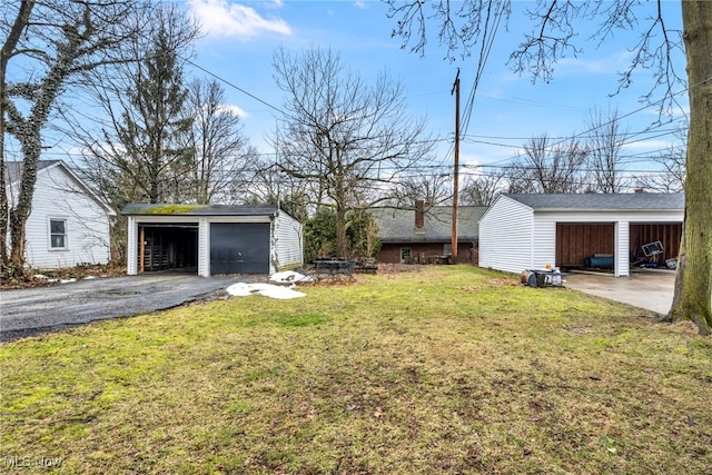 view of yard with a garage and an outbuilding