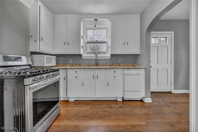 kitchen featuring white appliances, white cabinetry, dark wood-style flooring, and a sink