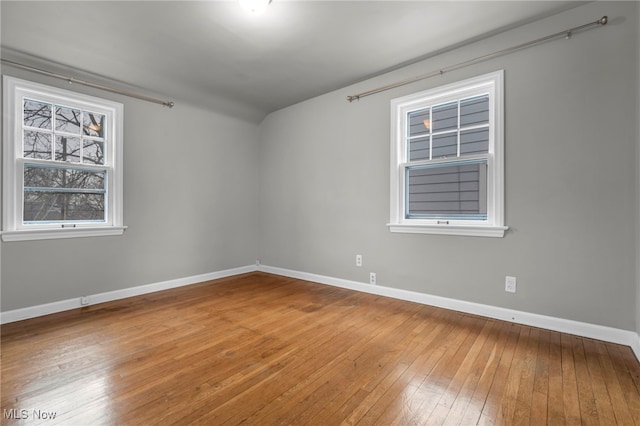 spare room featuring baseboards and hardwood / wood-style floors