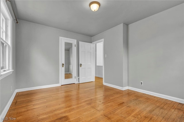 unfurnished bedroom with light wood-type flooring and baseboards