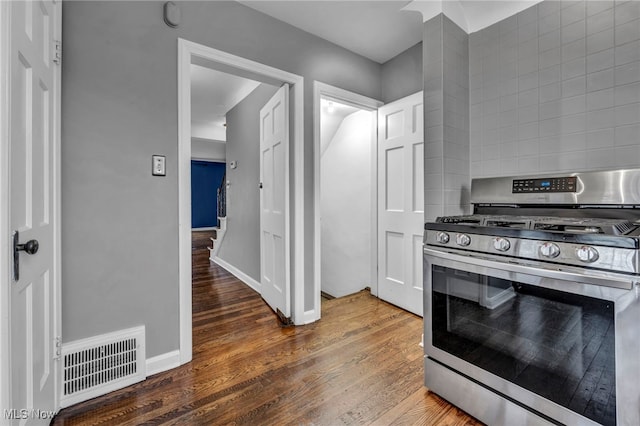 kitchen with visible vents, backsplash, stainless steel gas stove, wood finished floors, and baseboards