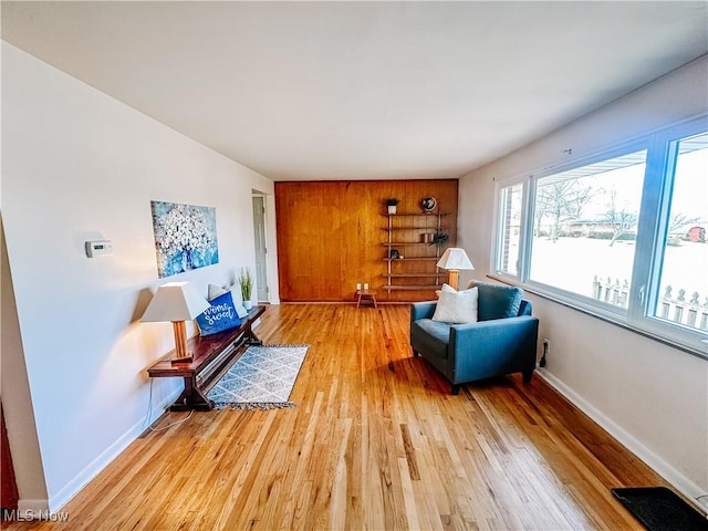 living area with light wood-type flooring and baseboards