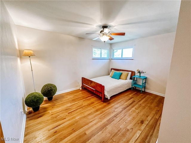 bedroom with light wood-type flooring, ceiling fan, and baseboards