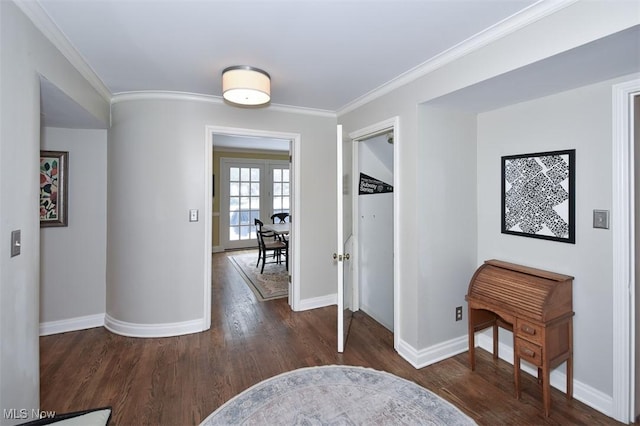 hallway featuring crown molding, baseboards, and wood finished floors