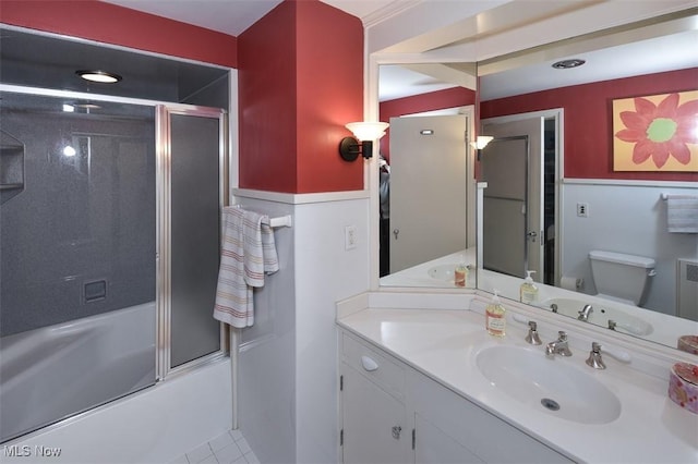 bathroom with vanity, toilet, and bath / shower combo with glass door